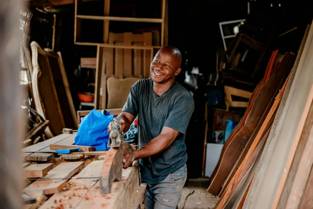 Charpentier africain travaillant le bois dans son atelier