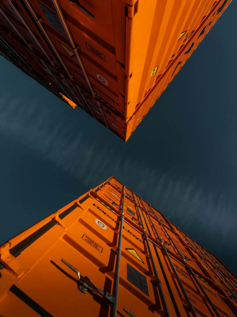 Conteneurs orange en contre-plongée sur un ciel sombre