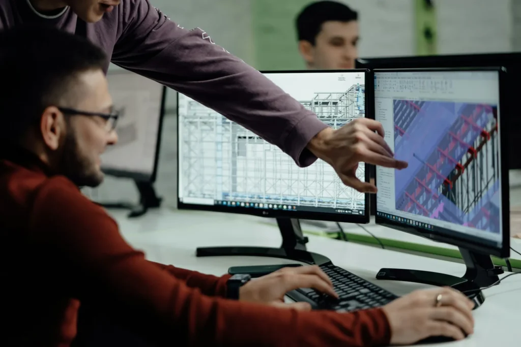 Ingénieurs en réunion de coordination BIM devant la maquette numérique 3D