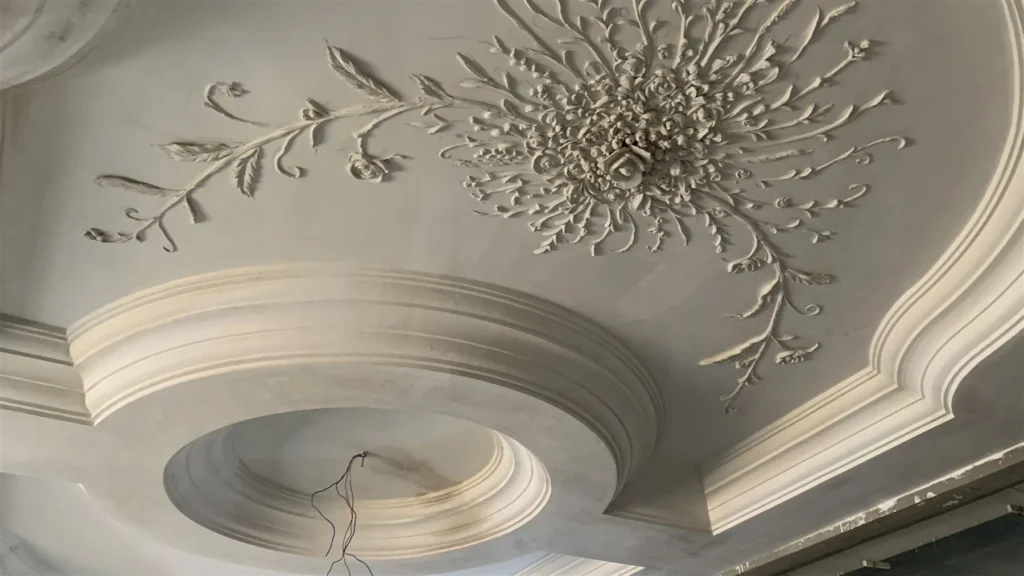 Caisson circulaire en staff et ornement floral sculpté au plafond