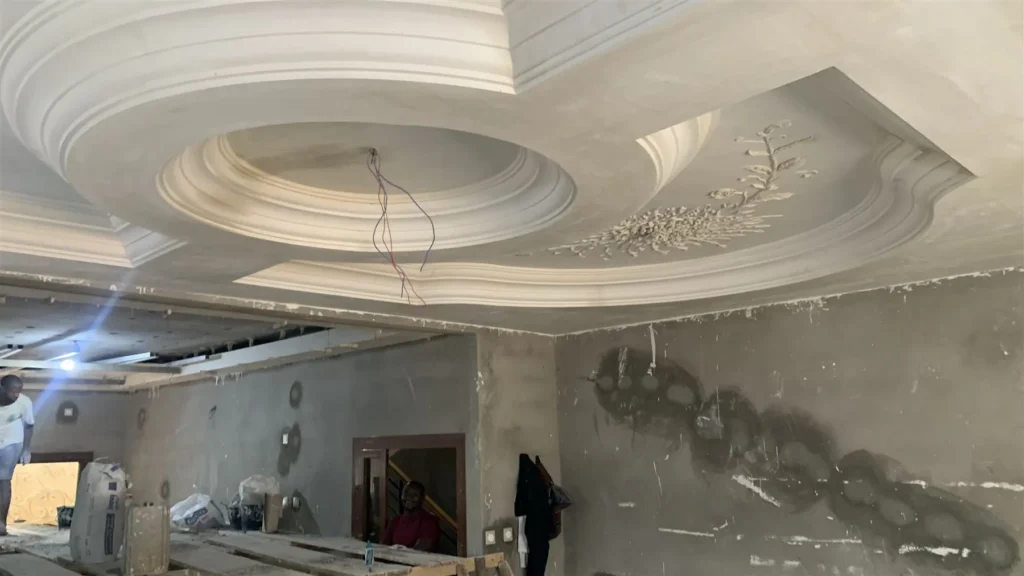 Faux plafond en staff aux courbes et caissons superposés dans un salon