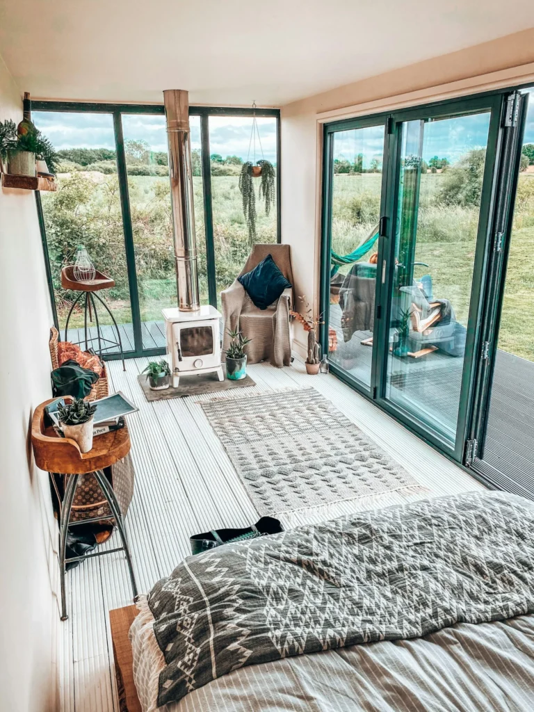 Chambre lumineuse d'une maison container ouverte par une baie vitrée