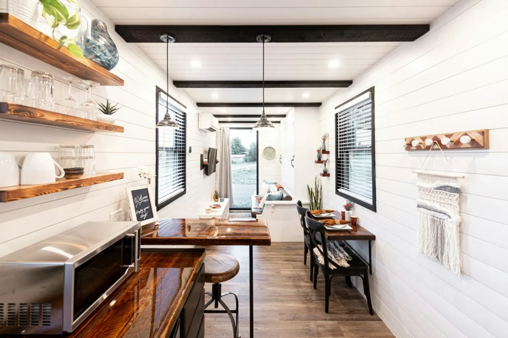 Intérieur d'une maison container avec cuisine et coin repas en bois