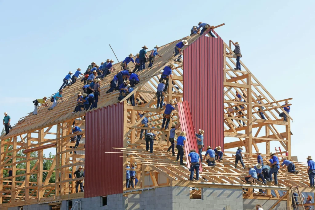 Équipe de charpentiers posant une charpente bois sur une maison