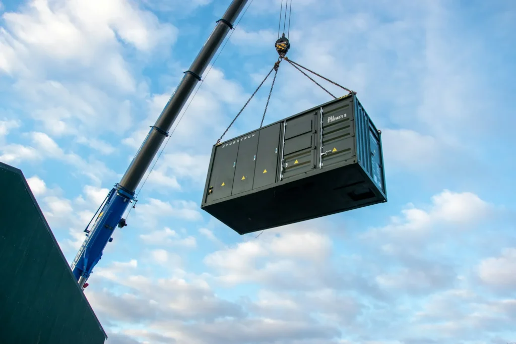 Grue levant un module conteneur lors du montage