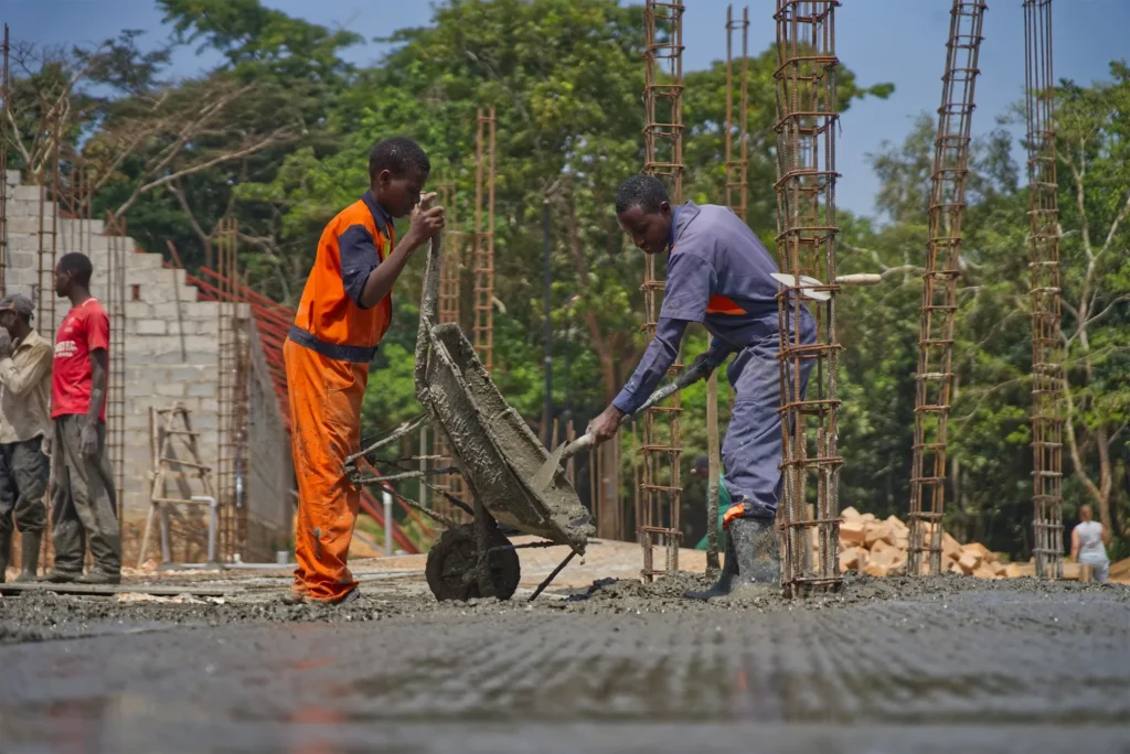 Maçons au travail sur une dalle en béton sur un chantier en Afrique