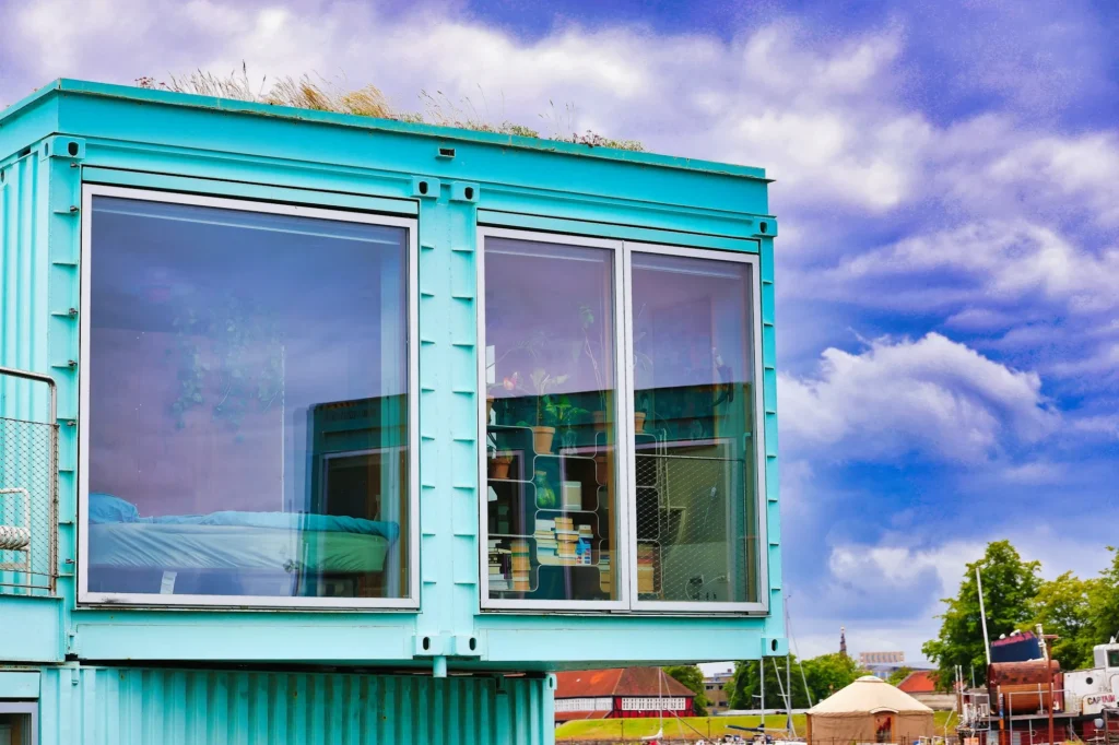Maison container turquoise avec grandes baies vitrées