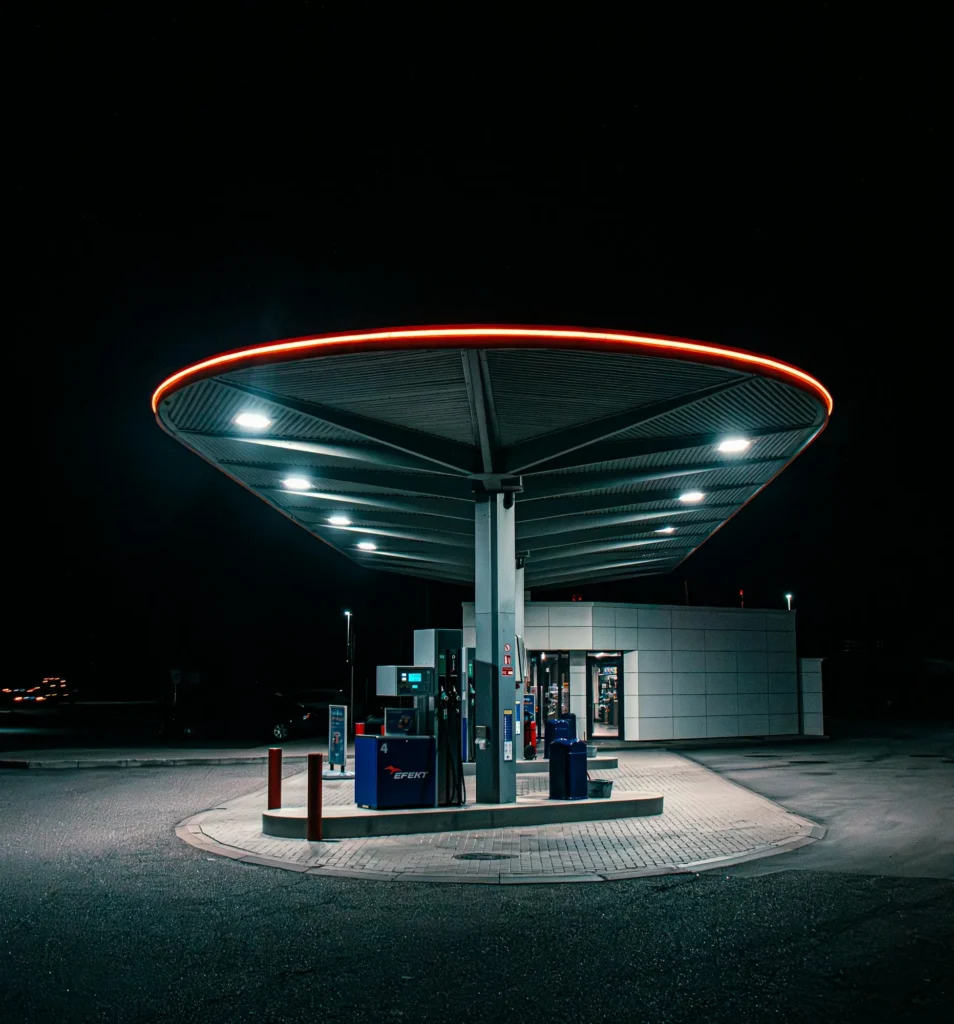 Station-service avec auvent circulaire éclairé la nuit