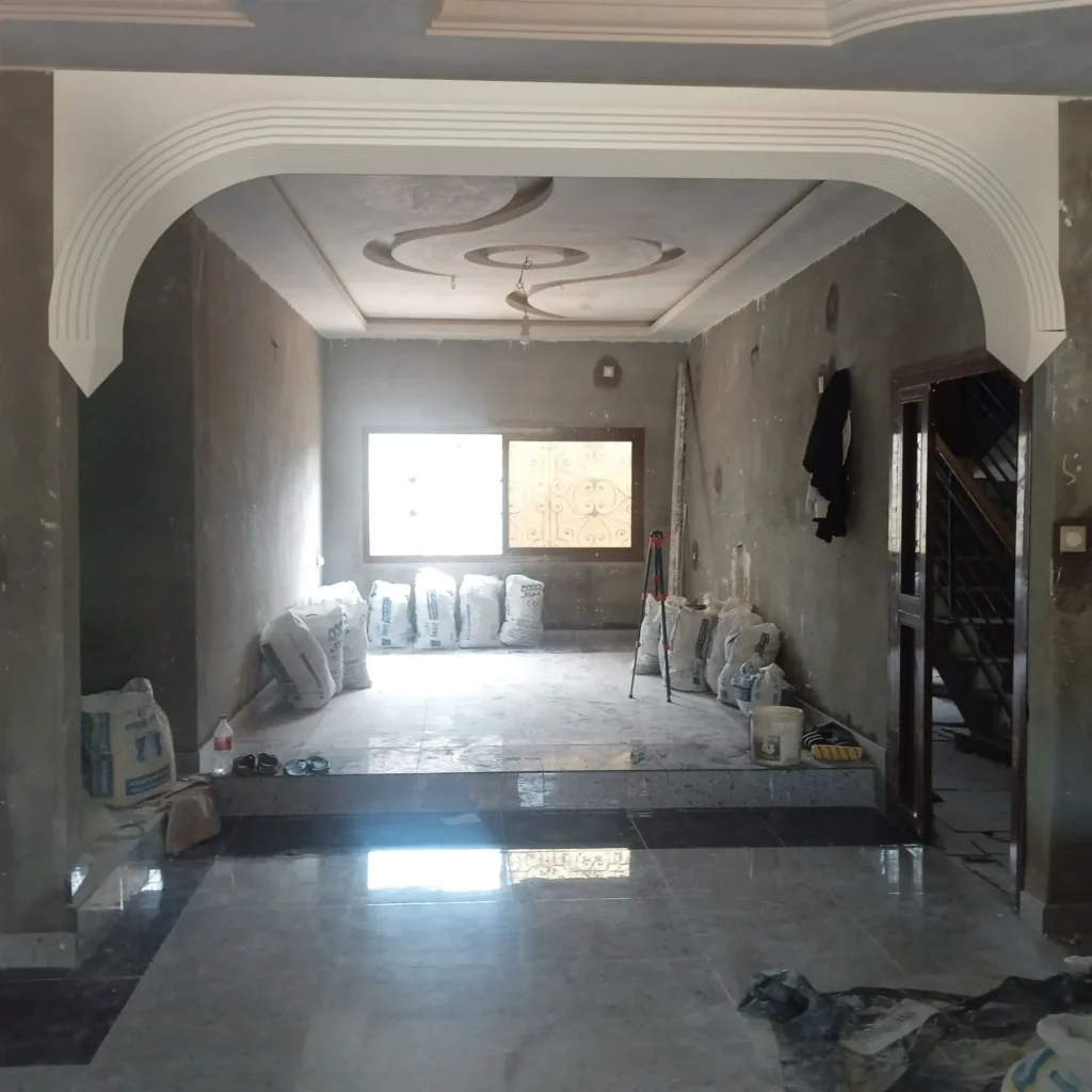 Voûte en staff encadrant l’entrée d’un séjour au faux plafond décoré